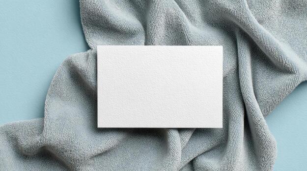 Blank White Card On Textured Blue Fabric Background. Minimalist Design For Branding Or Invitations photo