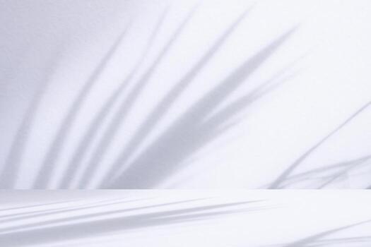 White table with palm tree shadow drop on white wall background for mockup product display photo