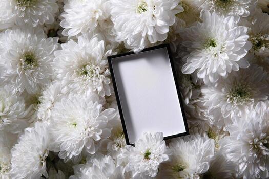 A white square frame sitting on top of a bunch of white flowers photo