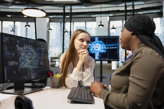 Young employee at desk pleading with AI tech startup manager for time off from work. Worker seeking help from artificial intelligence company team leader in professional workspace photo