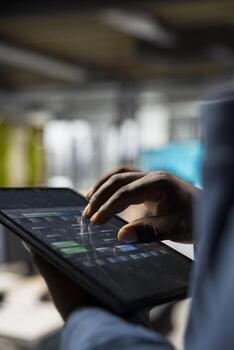 Close up of analyst focused on charts analysis on tablet to ensure expansion for IT company, reviewing insights and performance metrics for development strategy. Aligning objectives. photo