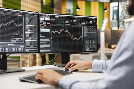 Day trader buys and sells stocks in prop firm office to capitalize on short term market fluctuations. Expert using technical indicators and price charts to identify fast profit opportunities photo
