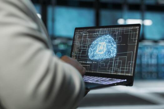 Close up of data center technician using artificial intelligence computerized model on laptop to oversee operations. Server farm IT expert working with AI machine learning algorithms on device photo