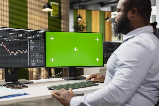 Risk analyst using green screen PC to evaluate trading strategies, minimizing losses and improve returns. Expert using data reports on chroma key computer to assess financial markets volatility photo