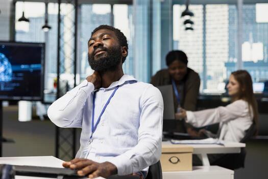 cansado sistema administrador a trabajo relajante rígido cuello mientras utilizando ai herramientas a automatizar rutina codificación tareas. agotado eso empleado masajear cuello a eliminar dolor, utilizando artificial inteligencia foto
