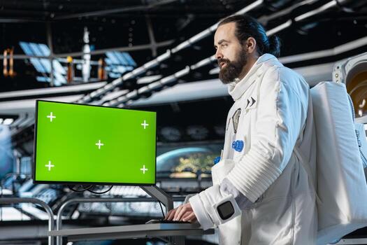 Cosmonaut verifying navigation coordinates on green screen monitor, preparing for planetary mission. Astronaut using mockup display, beginning landing procedures on solar system planet photo