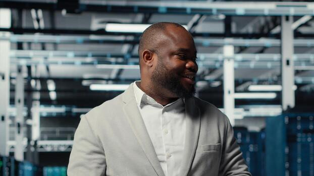 gerente caminando en alto tecnología datos centrar instalaciones con múltiple filas de completamente Operacional servidor bastidores supervisor supervisando servidor cubo construido para digital almacenamiento sistemas, cámara si foto