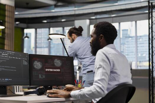 Computer scientist blocking network intrusion affecting office equipment. IT employee responding to live cyberattack warning popup on PC, neutralizing hacker breach in tech startup workspace photo