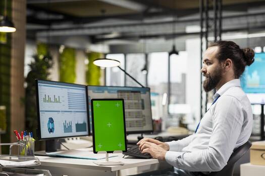 Executive assistant analyzing KPI metrics on pc next to tablet with mockup, handling task completion with infographics and data analytics on the computer. Businessman seeing insights. photo