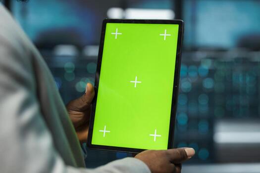 Close up of data center engineer using isolated screen tablet, managing rackmounts energy consumption. Worker using chroma key device used for automation and monitoring processes in server room photo