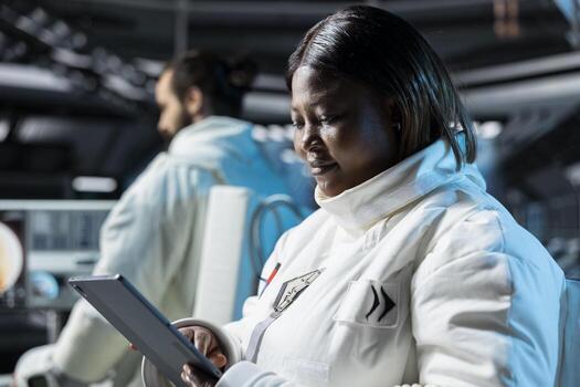 Female astronaut in spacecraft calibrating sensors and conducting safety checks using tablet. Woman in spaceship monitoring life support systems on device during planetary exploration photo