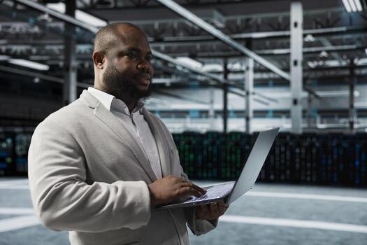 Engineer in server farm auditing systems for vulnerabilities, checking recovery plan. Data center IT specialist troubleshooting connectivity issues, making sure rigs are functioning optimally photo