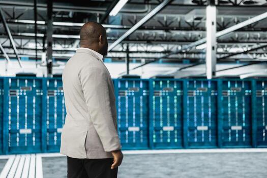 System administrator working in data center overseeing international user traffic. IT expert walking in server farm workplace hosting websites and delivering web content to online customers photo