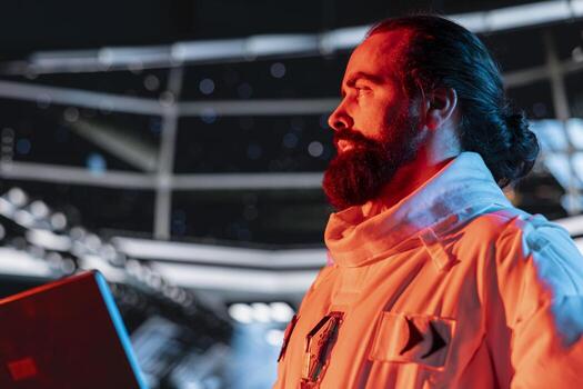 Spaceman seeing red warning light flashing during space travel operations. Astronaut wearing spacesuit inside futuristic spacecraft having trouble with hazard alarm in cockpit photo