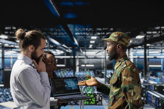 Army technicians in command center server farm using artificial intelligence to detect cyber threats. Military data center IT experts use AI detection software to secure defense systems. photo