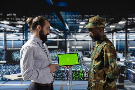 IT military engineering team using mockup display on tablet, working on national defense mission on industrial platform in control room base. Protecting networks against cyber threats. photo