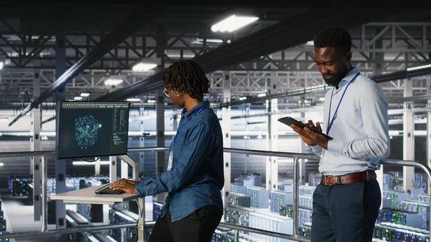 Engineers working together on data center industrial platform, completing software updates. Server hub colleagues doing brainstorming, finetuning server rig configurations photo