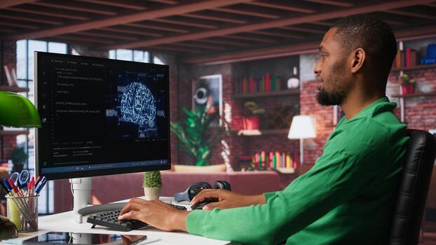 African american engineer coding a neural network AI brain model for machine learning and deep learning, solving IT support tasks on pc. Debugging software and checking for errors. Camera B. photo