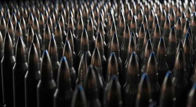 Array of metallic rifle cartridges in parallel rows, close up view of ammunition photo