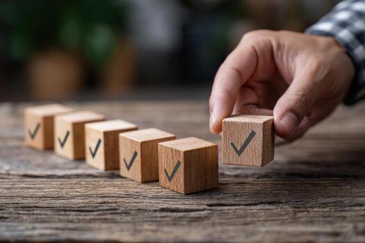 a checklist and task progress tracking concept. A hand placing the final checkmark on wooden blocks in a progress bar photo