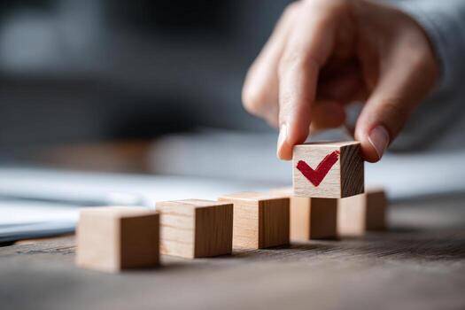 the checklist and task progress tracking concept. A hand placing the final checkmark on wooden blocks in a progress bar photo