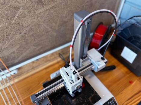 3d printer creating an object using red filament photo