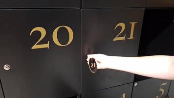 Hand unlocking numbered locker series with key in motion video