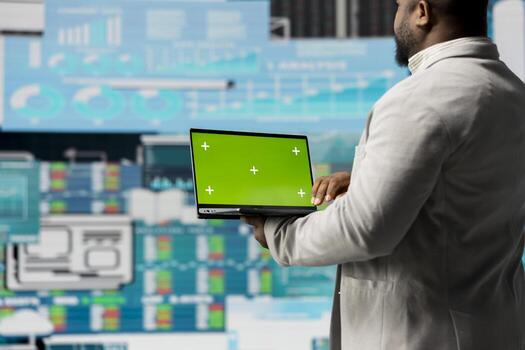 Black administrator holding device with green screen for analysis, reviewing monthly reports and infographics for company development. Good performance metrics for growth, forecasting. photo