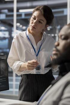 Data center engineering team using PC to update servers tech, configuring infrastructure. Server hub teamworking colleagues reviewing hardware analytics, ensuring reliable network operations photo