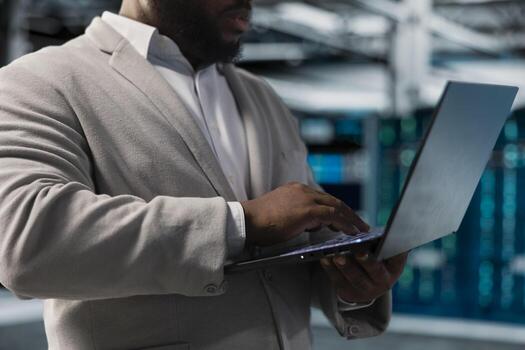 Close up of server hub worker running maintenance scans, fixing network issues affecting rigs performance. Data center admin running system diagnostic tests on laptop, tracking resource utilization photo