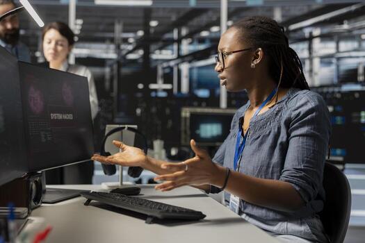 Woman working in server farm perturbed by malicious threats detected by cybersecurity systems. Stressed data center system administrator worried after detecting irregular network activity patterns photo