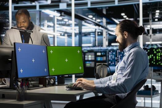 Data center technician programming diagnostic scripts on isolated screen PC, examining infrastructure. Server farm employee evaluating performance metrics on chroma key computer photo