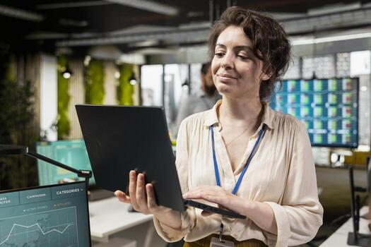 Woman administrator reviewing data reports and planning on laptop to build a new vision, focusing on KPI metrics evaluation and report writing to create solutions for objectives alignment. photo