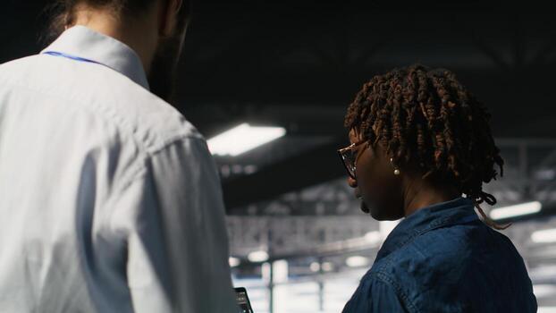 Server farm manager overseeing work done by engineer reviewing neural network code and LLM visualization dashboards. Team leader supervising worker monitoring AI system performance photo