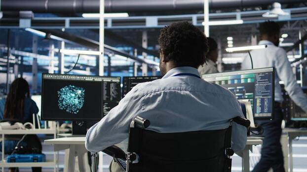 Server room programmer with paraplegia interprets data analytics graphs. Man in wheelchair using artificial intelligence program showing predictive system metrics in data center, camera A photo