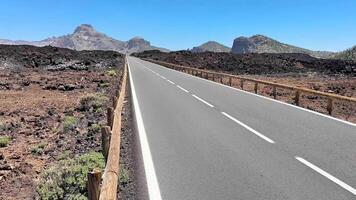 Enjoy a breathtaking view of a winding road amidst stunning volcanic rocks and bright blue skies above video