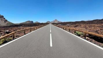A stunning view of a winding road through a picturesque volcanic landscape beneath a vibrant blue sky video