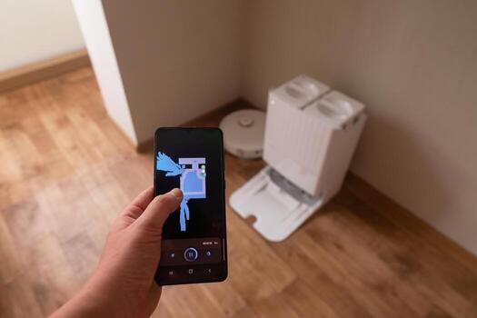 Smartphone screen displays app for controlling robot vacuum using modern technology for efficient home cleaning and convenience photo