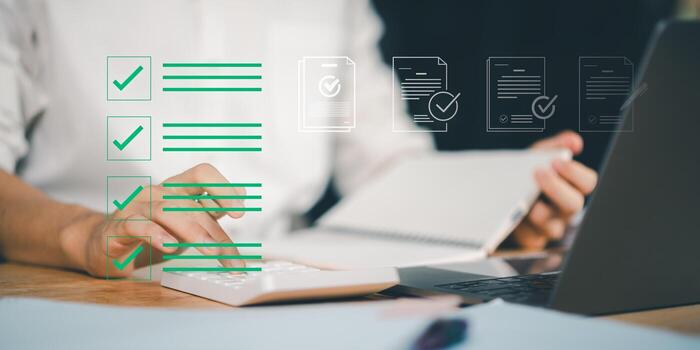 Completing digital checklist on a laptop with icons of approved documents, representing task management, productivity, and efficient workflow organization in a business setting. photo