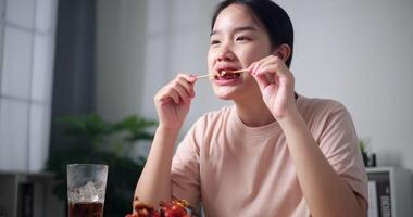 palmare Basso angolo Visualizza sparo, asiatico donna godendo delizioso barbecue nel un' accogliente cenare camera. fatti in casa cibo. mangiare con rilassamento video