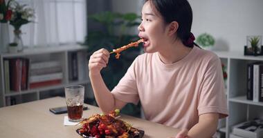 palmare sparo, sorridente asiatico donna godendo delizioso barbecue nel un' accogliente cenare camera. mangiare con rilassamento video