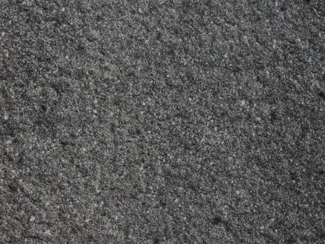close up of the surface of a granite rock which has a rough texture and black and gray color photo