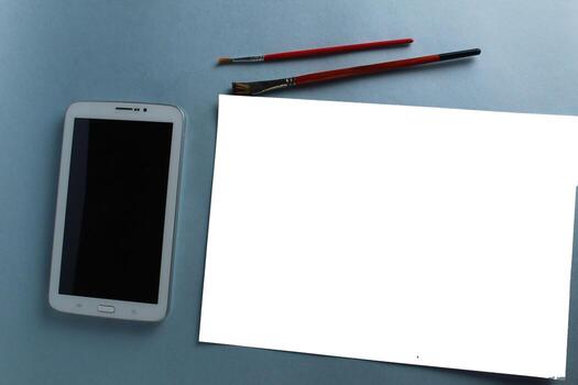 online. training drawing tablet and sheet of white paper with a pattern on a light blue background with a mock up and a place for text photo