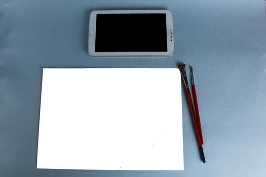 online training. drawing tablet and sheet of white paper with a pattern on a light blue background with a mock up and a place for text photo