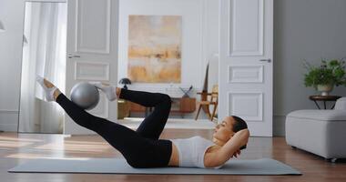 Frau durchführen Fahrrad knirschen Übung auf Yoga Matte im modern Leben Zimmer mit stilvoll Dekor video