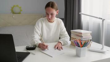 studerande studerar intensivt, använder sig av bärbar dator, kalkylator, och anteckningsbok på vit tabell, fokusera på pedagogisk uppgifter med koncentrerad ansträngning video