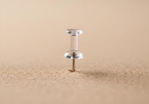 Minimalist photo of a single push pin inserted into cork board with ultra-sharp focus and soft clean background blur in modern office style