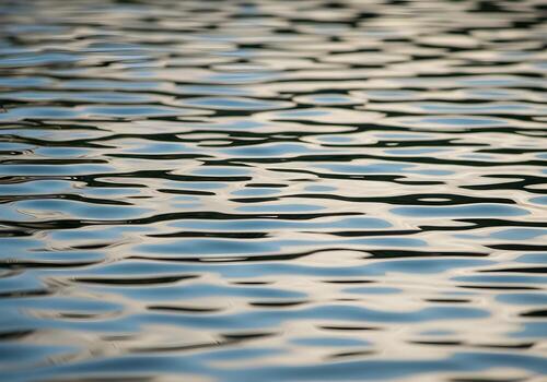Water ripple reflections creating abstract patterns on surface with sunlight, high-resolution clean background without blur or human presence photo