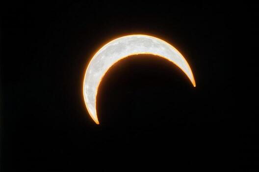 A crescent moon is in the sky with on black background photo