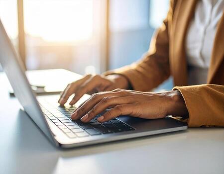 A person typing on a laptop computer photo